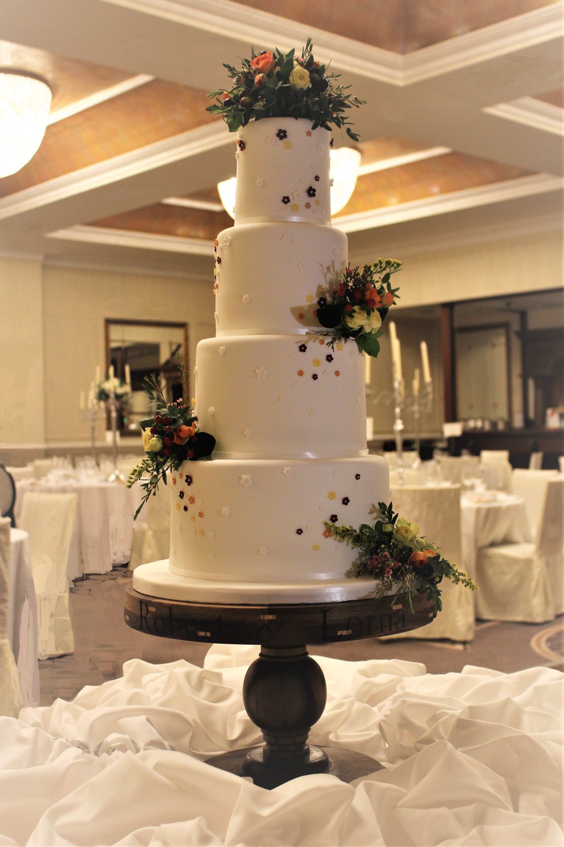 Beautiful autumnal colours were chosen for the flowers and decoration of this four-tier wedding cake