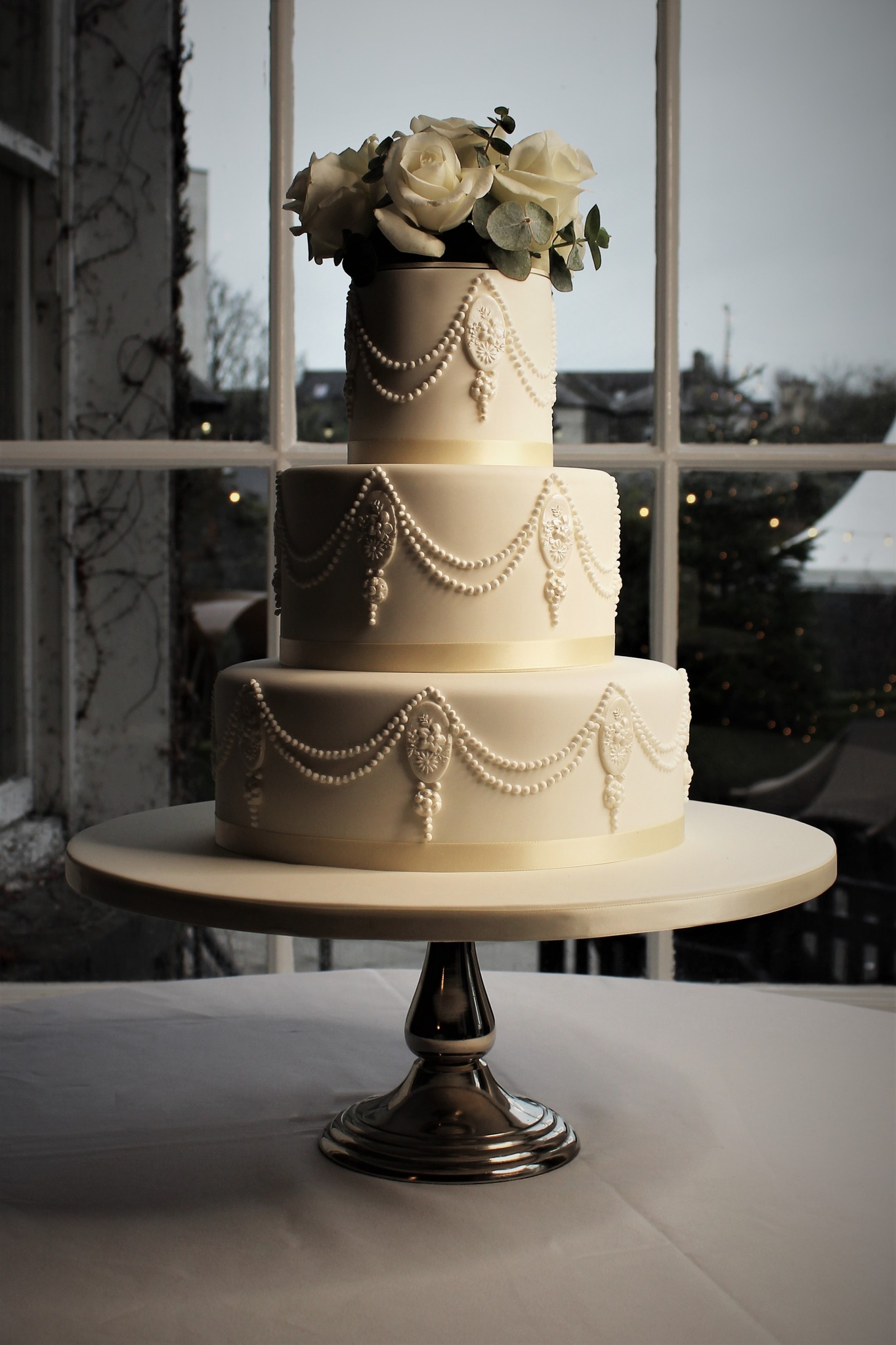Three tiered white cake which resembles the plaster work at the Butler House