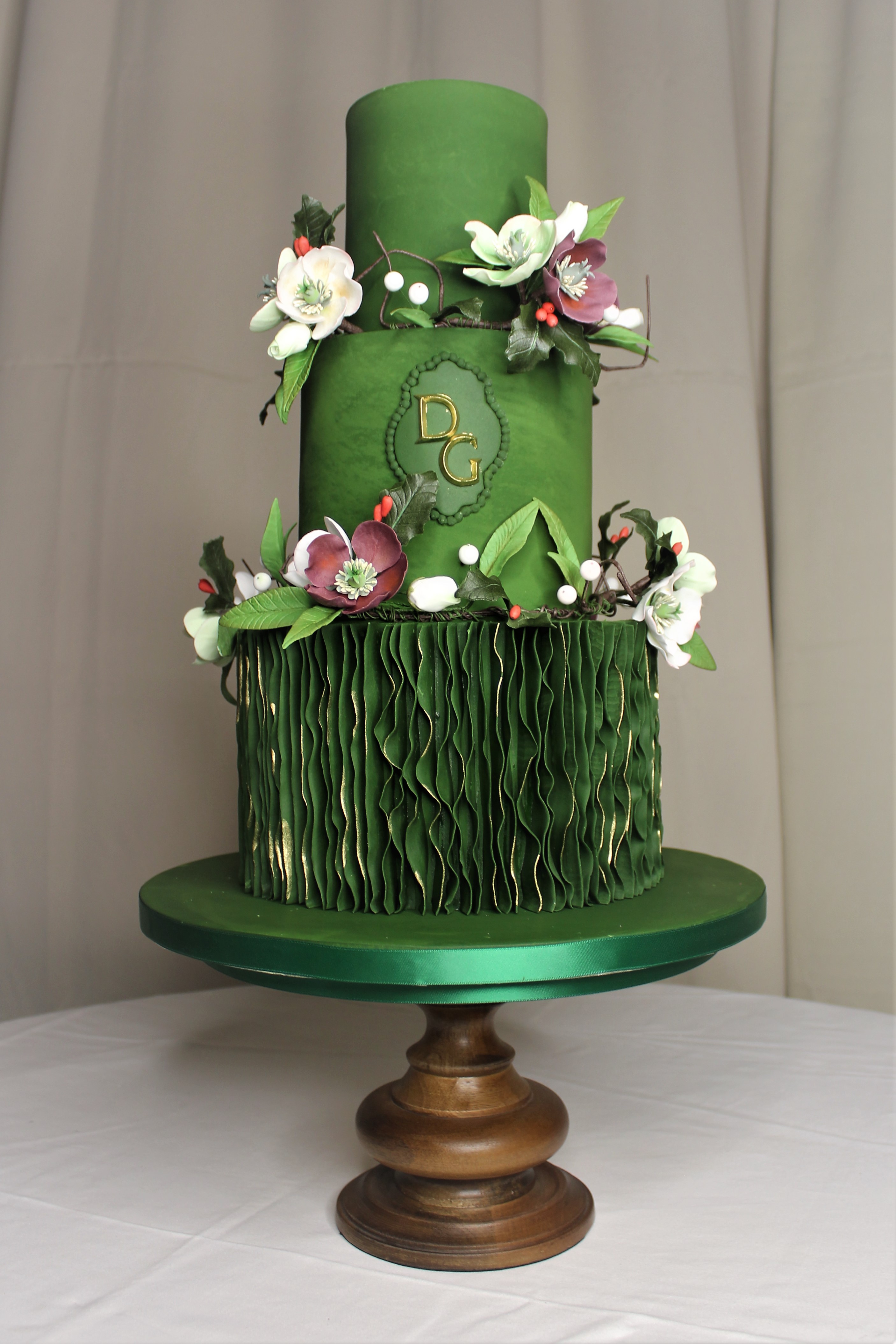 Three tiered green wedding cake with holly leaves incorporated