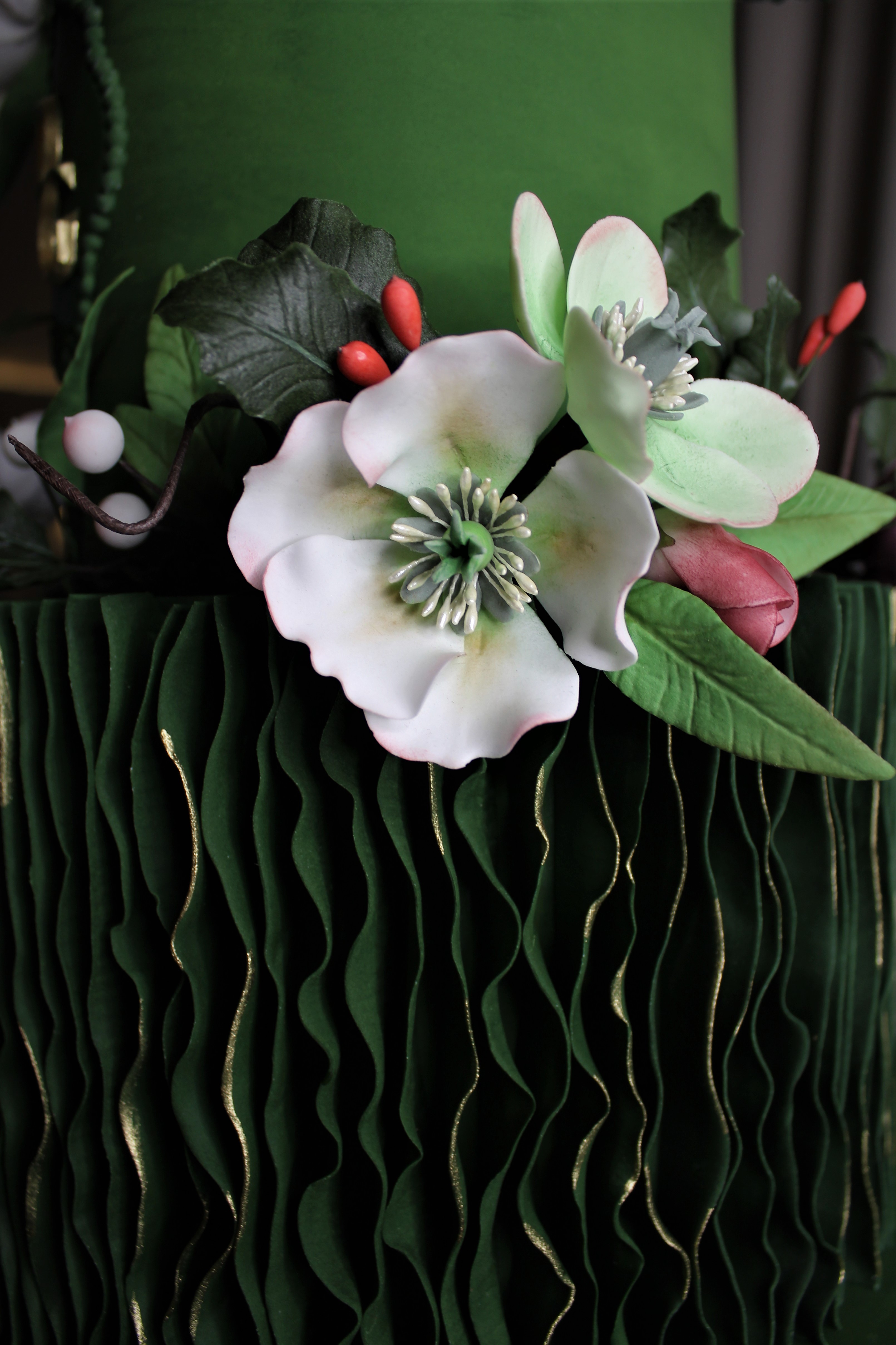 Close-up of fondant flowers and holly leaves