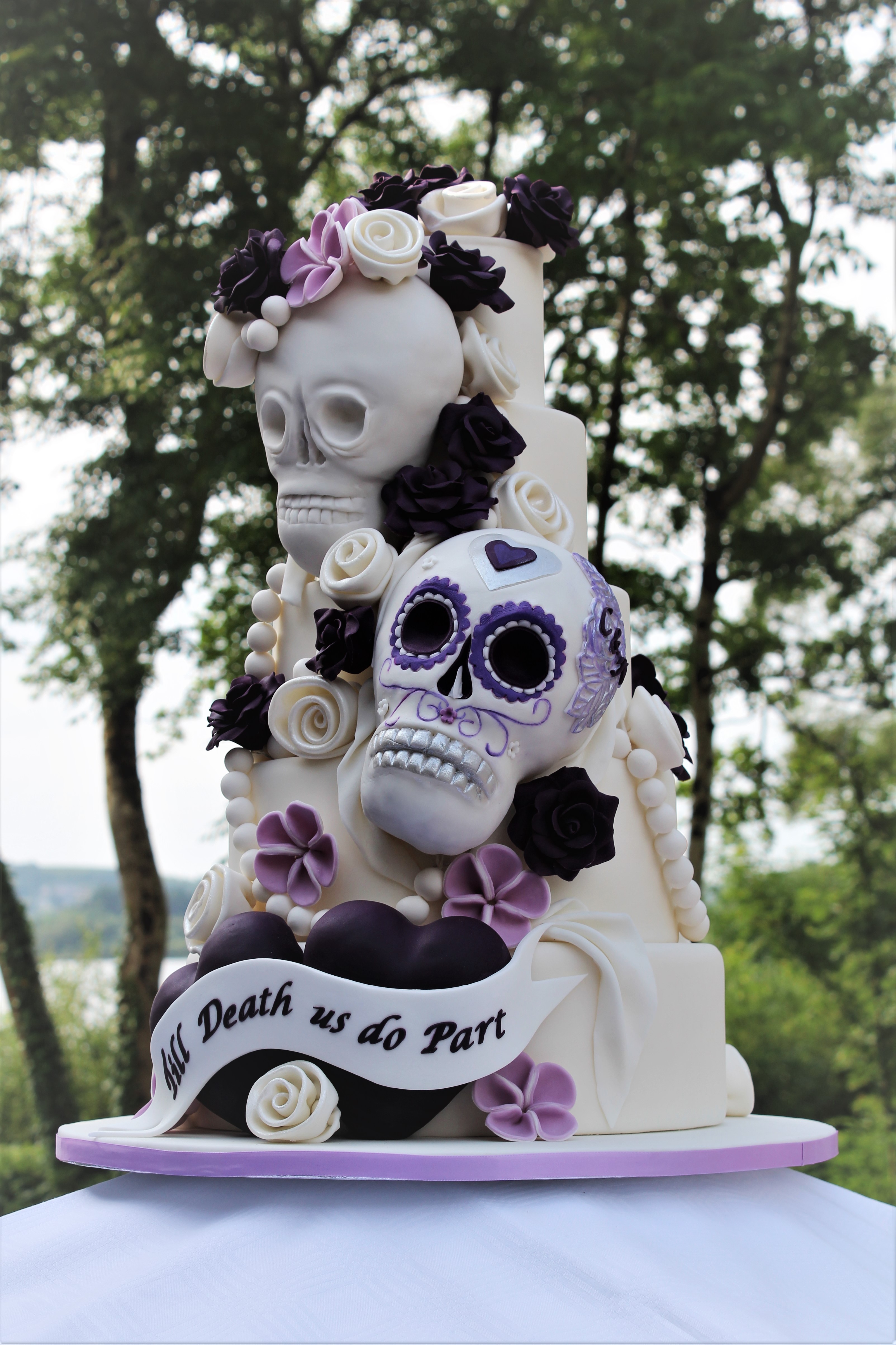 A five tier wedding cake, elaborately decorated with hand-made fondant flowers and skulls for a wedding at the spectacularly located Harvey’s Point, Donegal.
