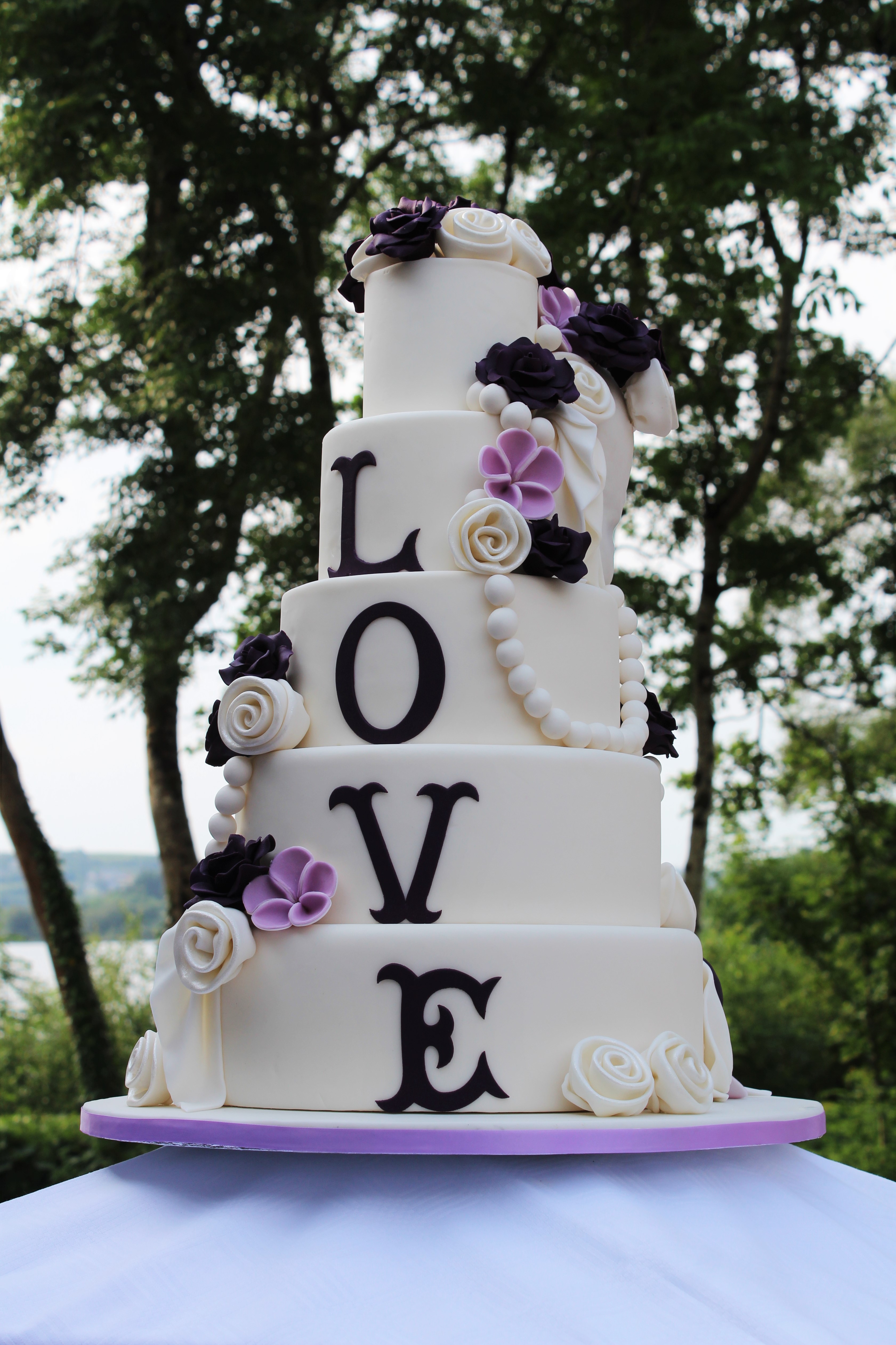 A five tier wedding cake, elaborately decorated with hand-made fondant flowers and skulls for a wedding at the spectacularly located Harvey’s Point, Donegal.