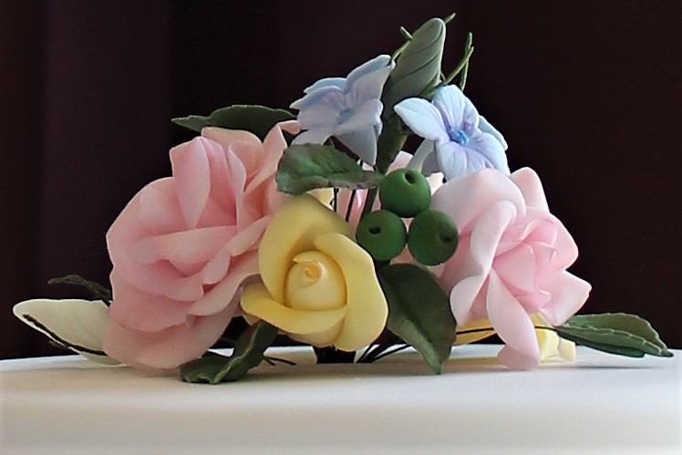 Close-up of fondant flowers ontop of red velvet cake